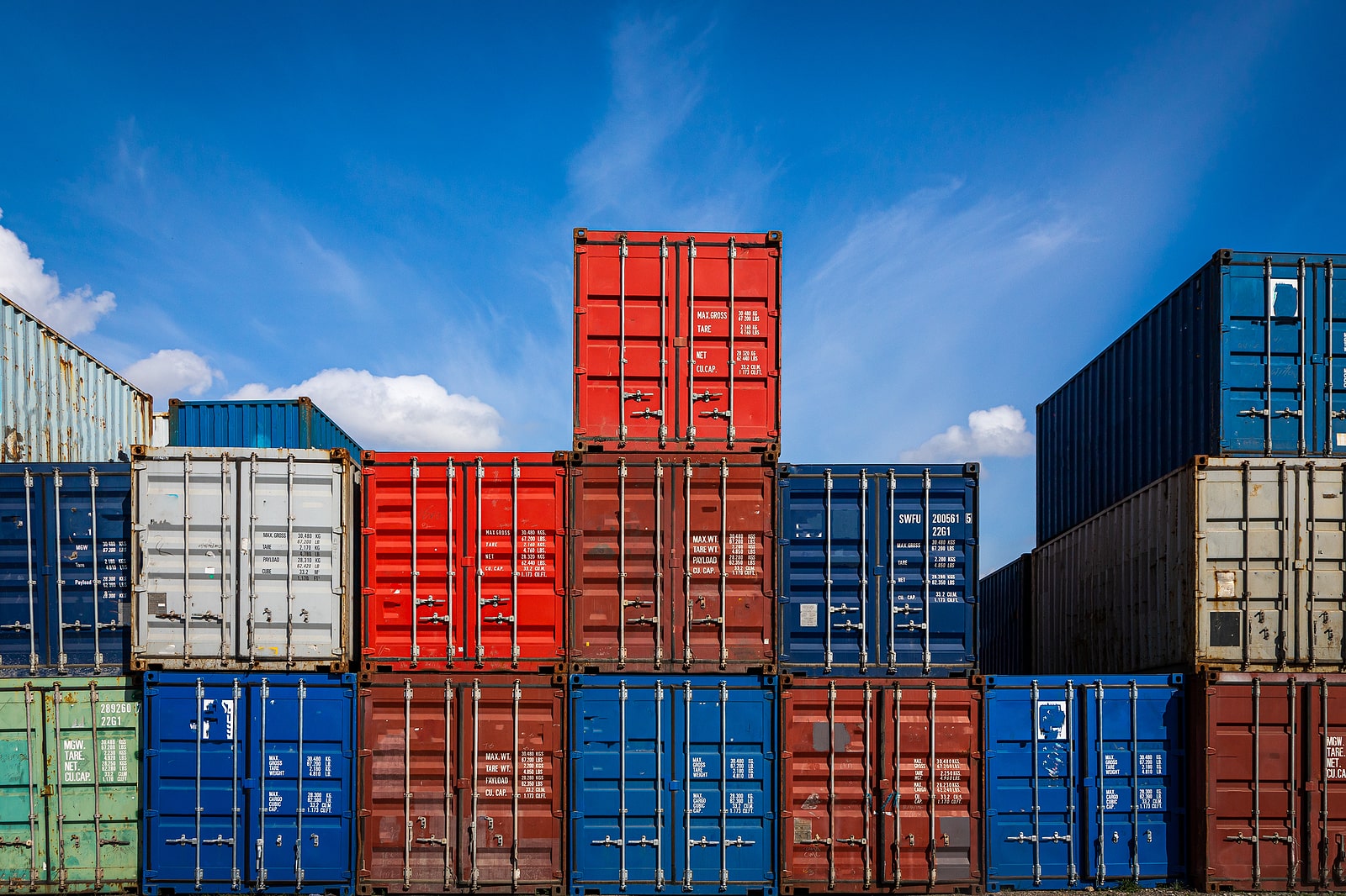 Storage containers stacked on top of each other beneath a blue sky.